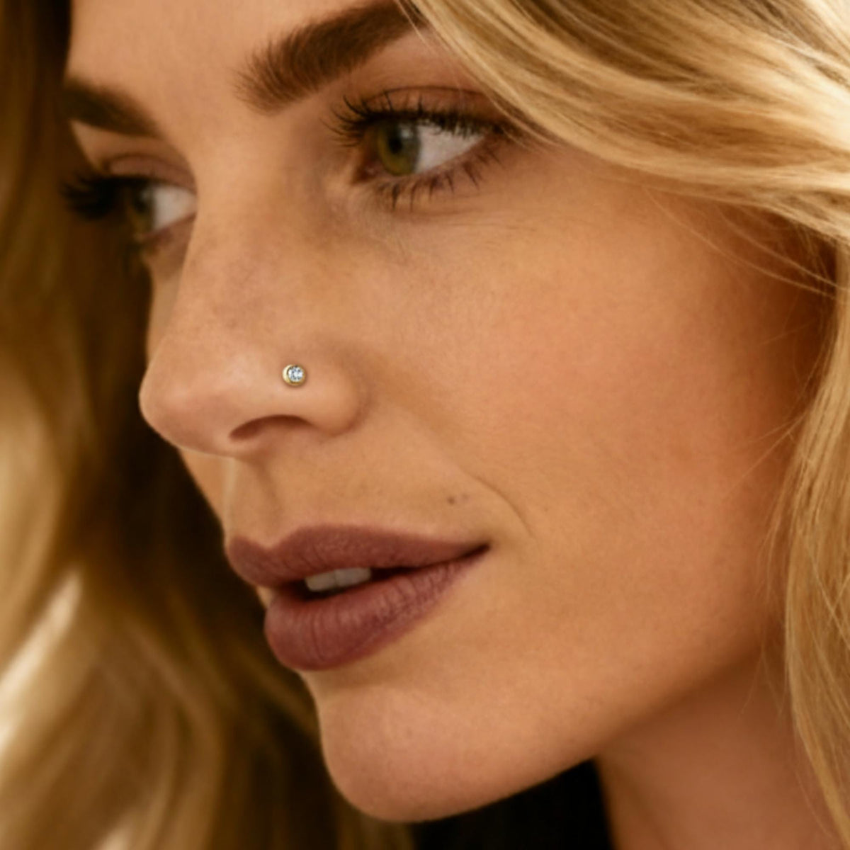 Bezel diamond nose stud worn by a sexy blond woman
