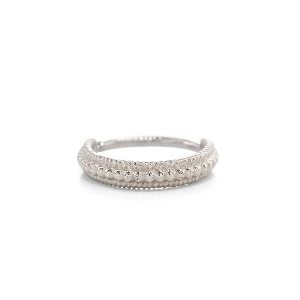A silver ring with a row of small, round stones or beads arranged in a decorative pattern.