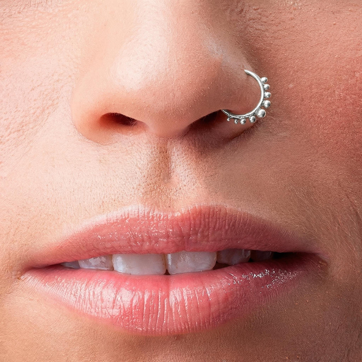 Silver Nose Ring: A close-up of a person's face, focusing on their lips and nose.