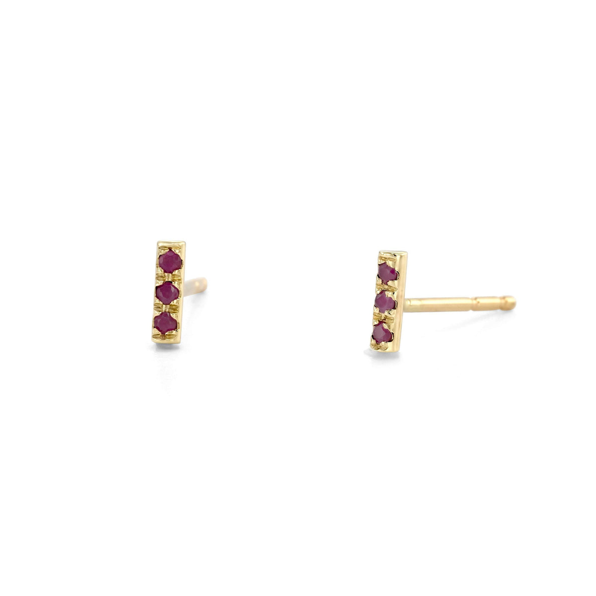 a pair of gold earrings with three red gemstones on each side, set in a simple gold design.