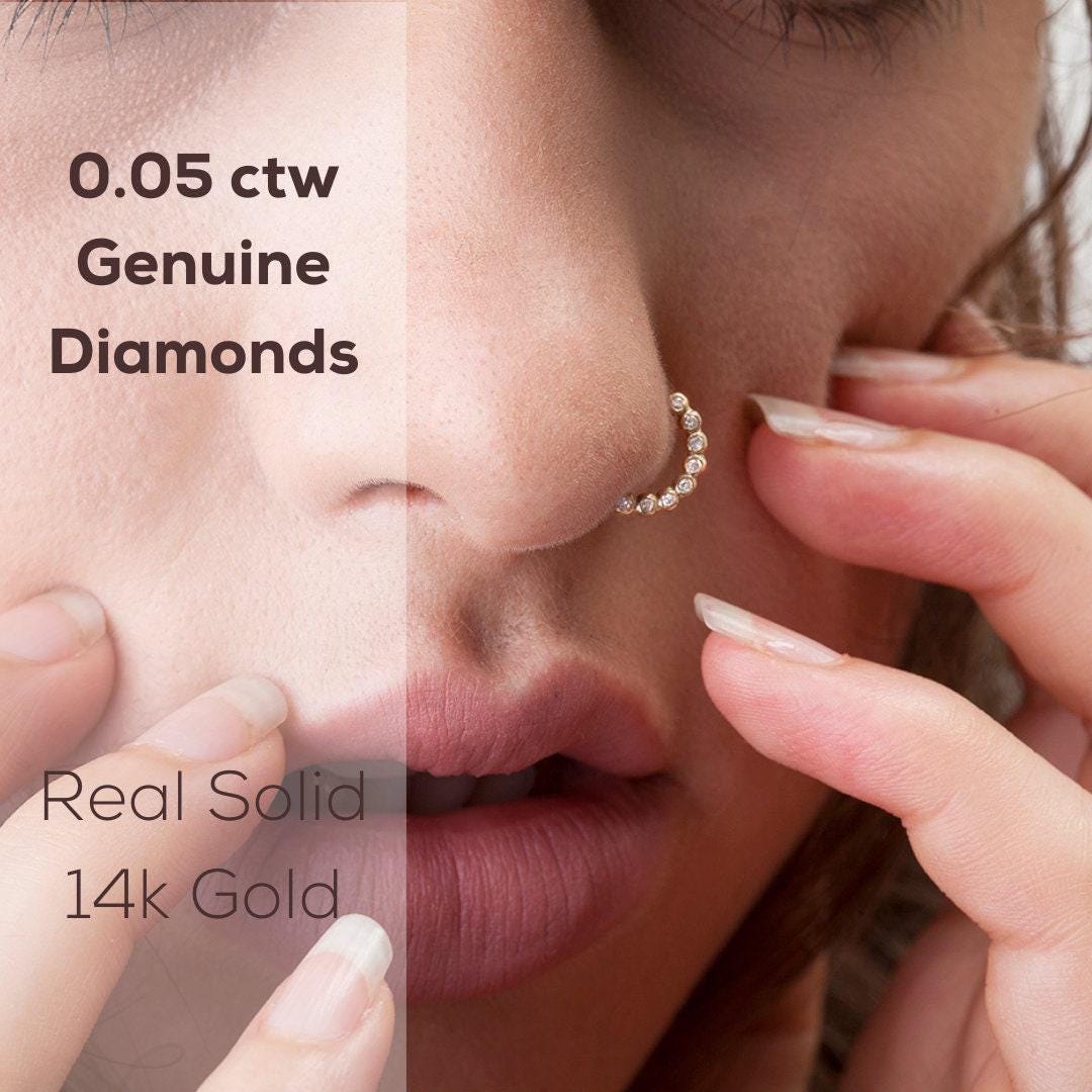 Diamond Nose Ring: The image is a close-up of a person's face, with their nose and fingers prominently featured. The text overlay provides information about the jewelry, specifically mentioning that the nose ring is genuine diamonds and that the jewelry is real solid black gold.