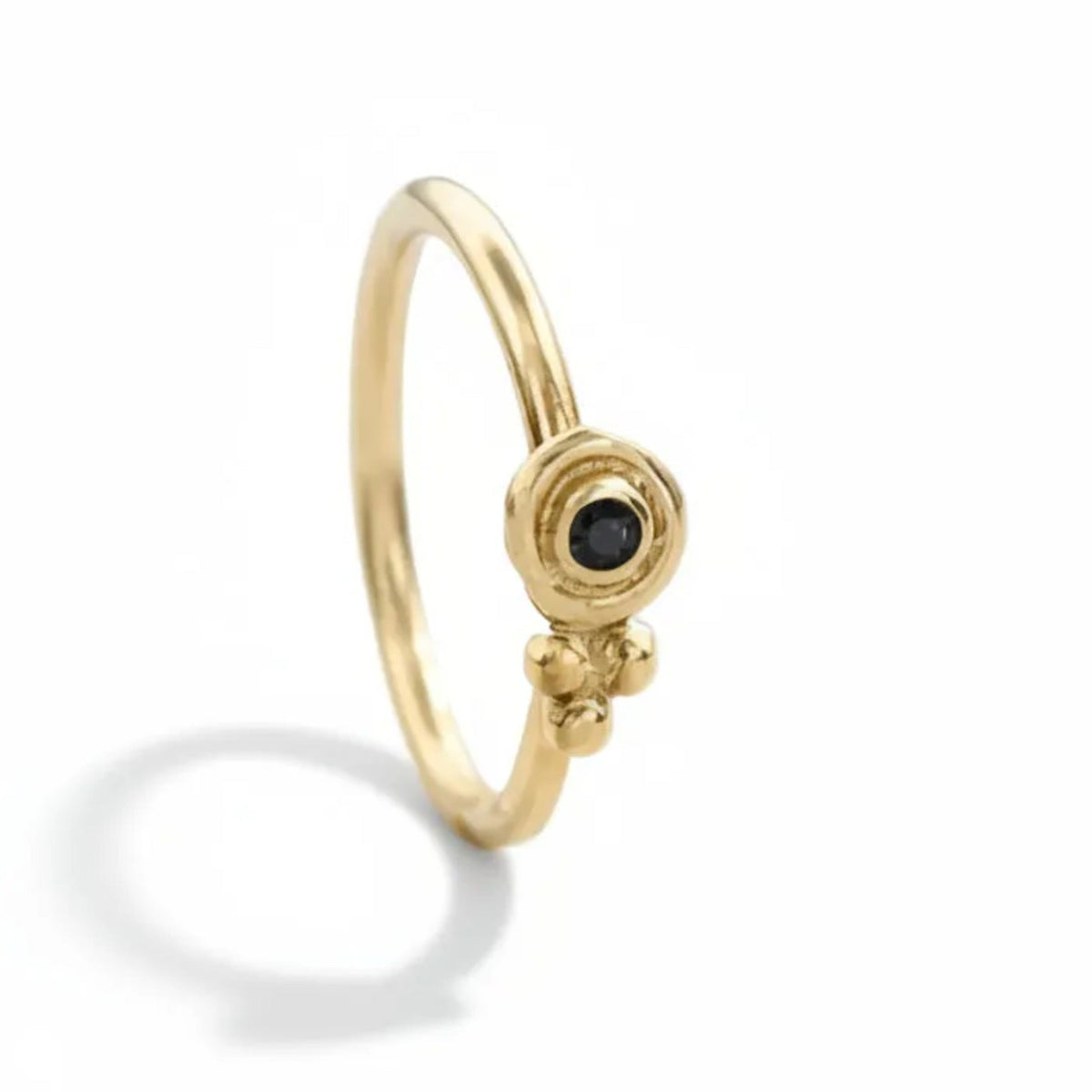 Black Diamond Nose Hoop: A gold ring with a black gemstone, possibly a diamond, set in the center.