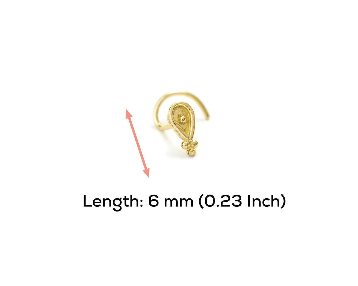 A gold-colored nose ring with a small decorative element is shown against a white background.