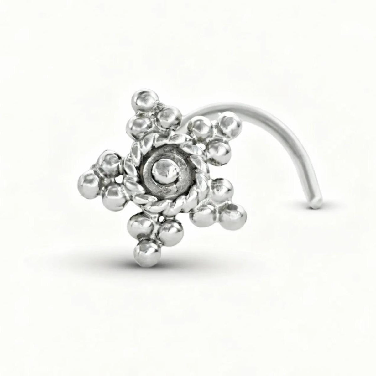 A silver-colored metal nose ring with a spiral design and small round beads.
