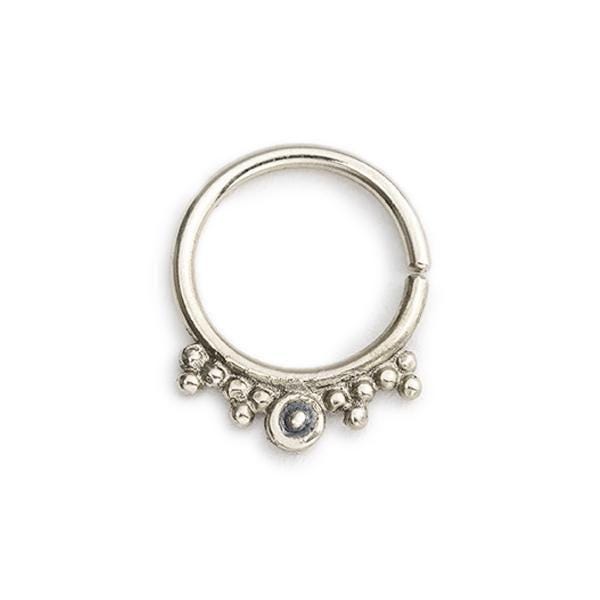 A silver-colored metal ring with a small circular gemstone or stone at the center, surrounded by small beads or stones.