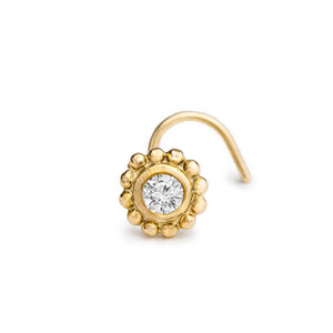 A gold-colored nose ring with a large, clear gemstone set in the center.