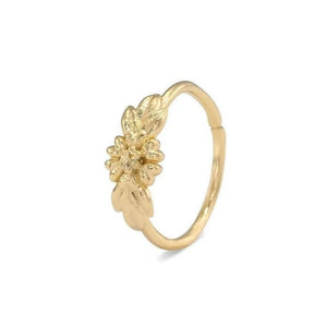 A gold-colored ring with a leaf-shaped design on the top.