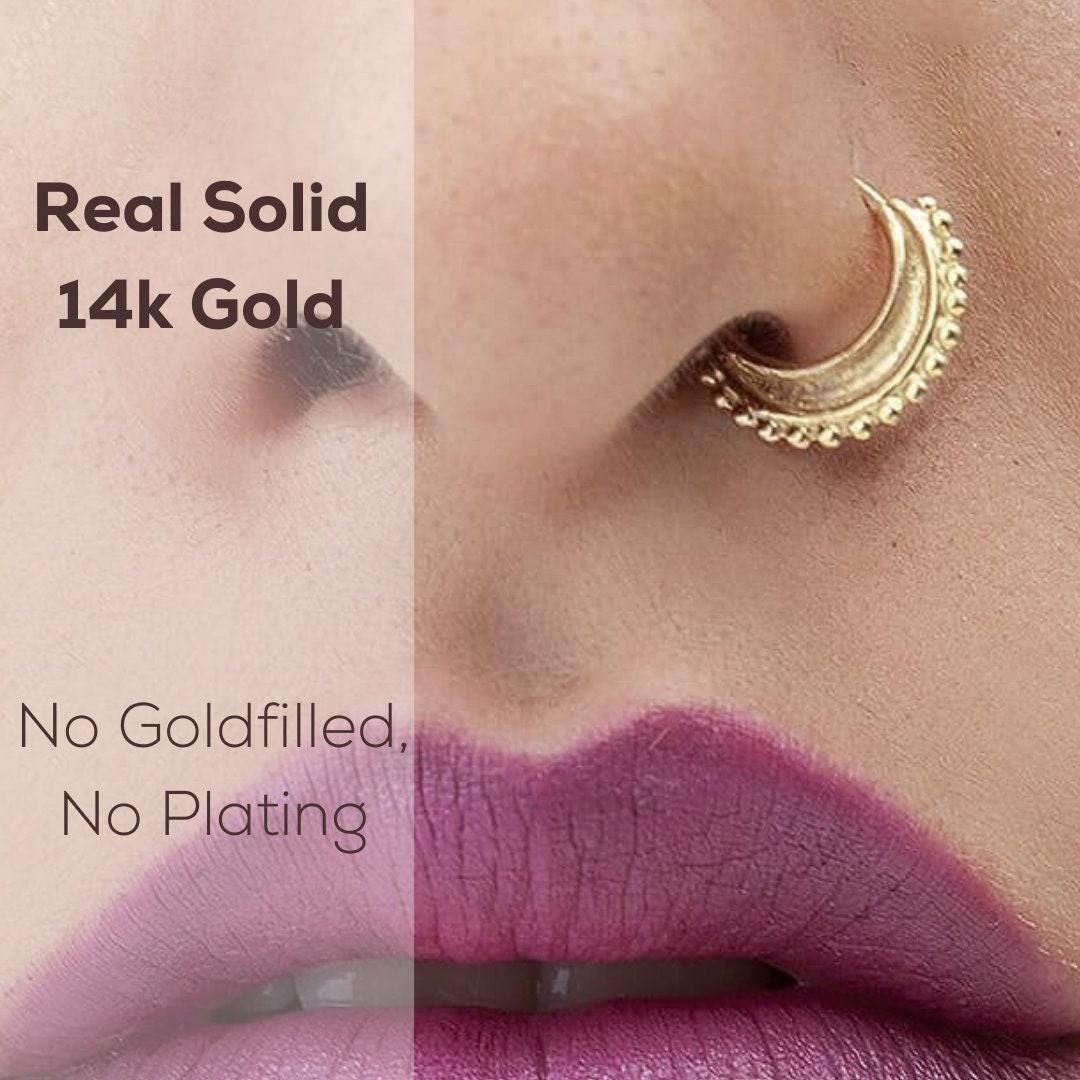 a close-up of a person's nose and lips with a gold nose ring and a purple lip liner.