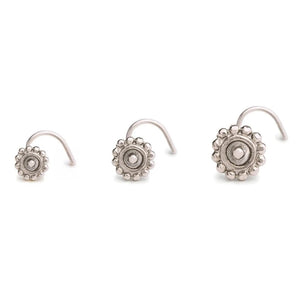 Three silver-colored metal earrings with intricate designs, arranged in a row against a white background.