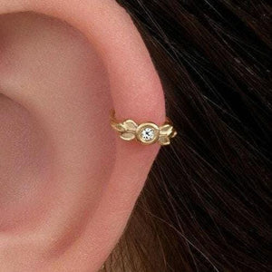 Cartilage Hoop Earring: A close-up of a person's ear with a gold earring featuring a small diamond.
