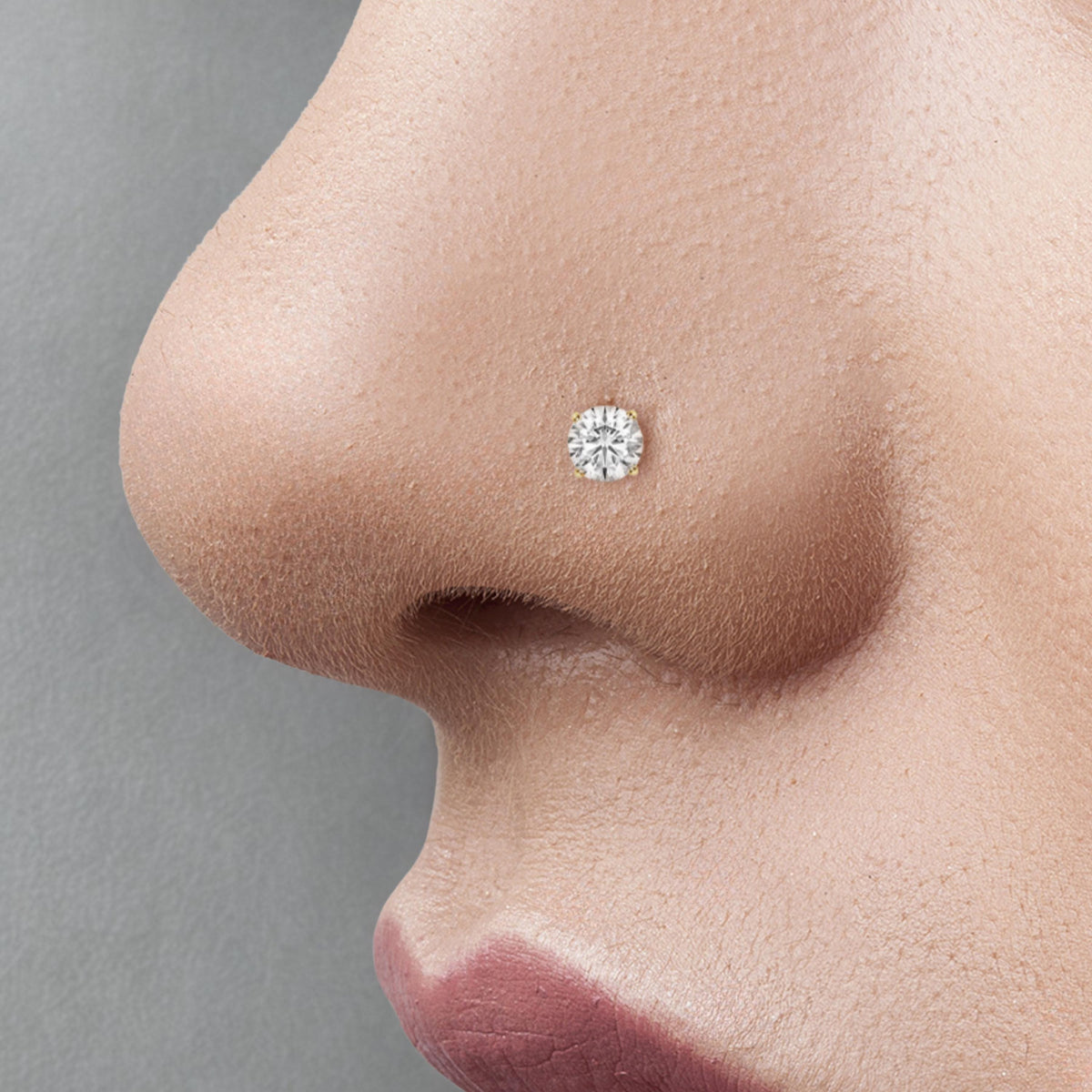 A close-up of a person's nose with a small diamond nose stud.