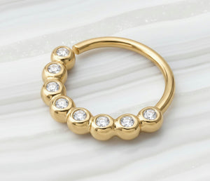 Diamond Nose Hoop: a yellow gold ring with a row of small diamonds set in it.
