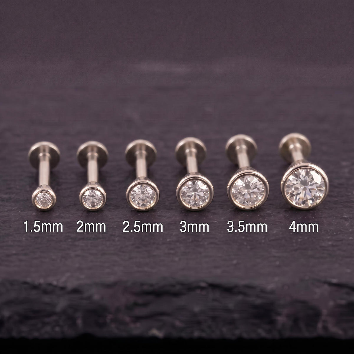 Genuine diamond white gold piercings, each with a different size ranging from 1.5mm to 4mm.