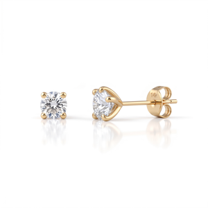 A pair of gold earrings with a single large diamond set in the center, resting on a gold post.