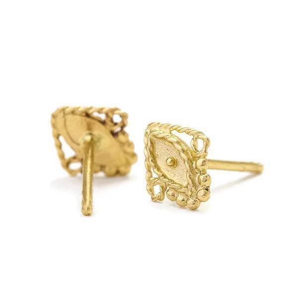 a pair of gold-colored earrings with intricate designs, including a central eye-shaped design and a twisted pattern around it.