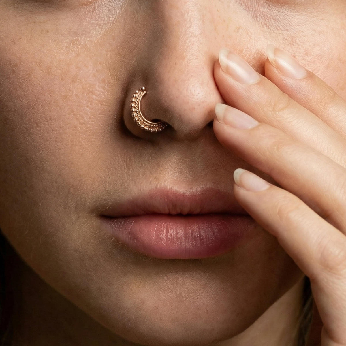 A close-up of a person's face, focusing on their nose and fingers.
