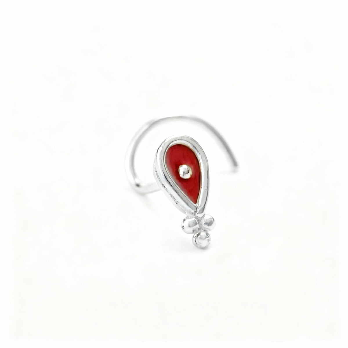 A silver nose ring with a red gemstone in the center.
