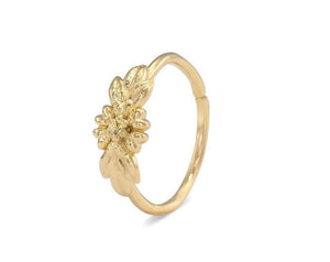 A gold-colored ring with a floral design on the side.