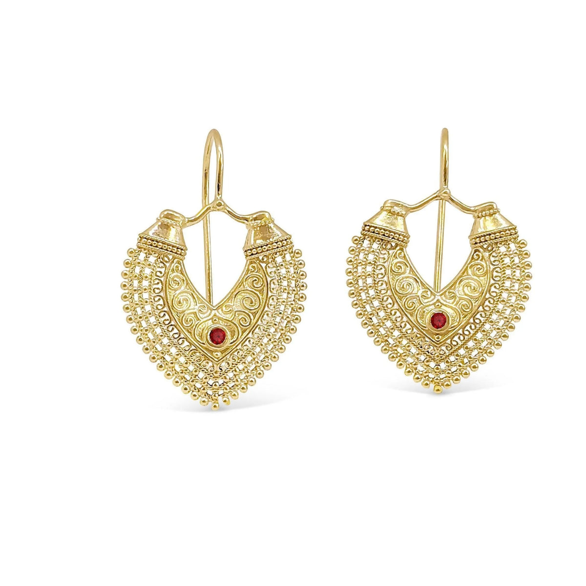 A pair of gold earrings with intricate designs and a red gemstone.