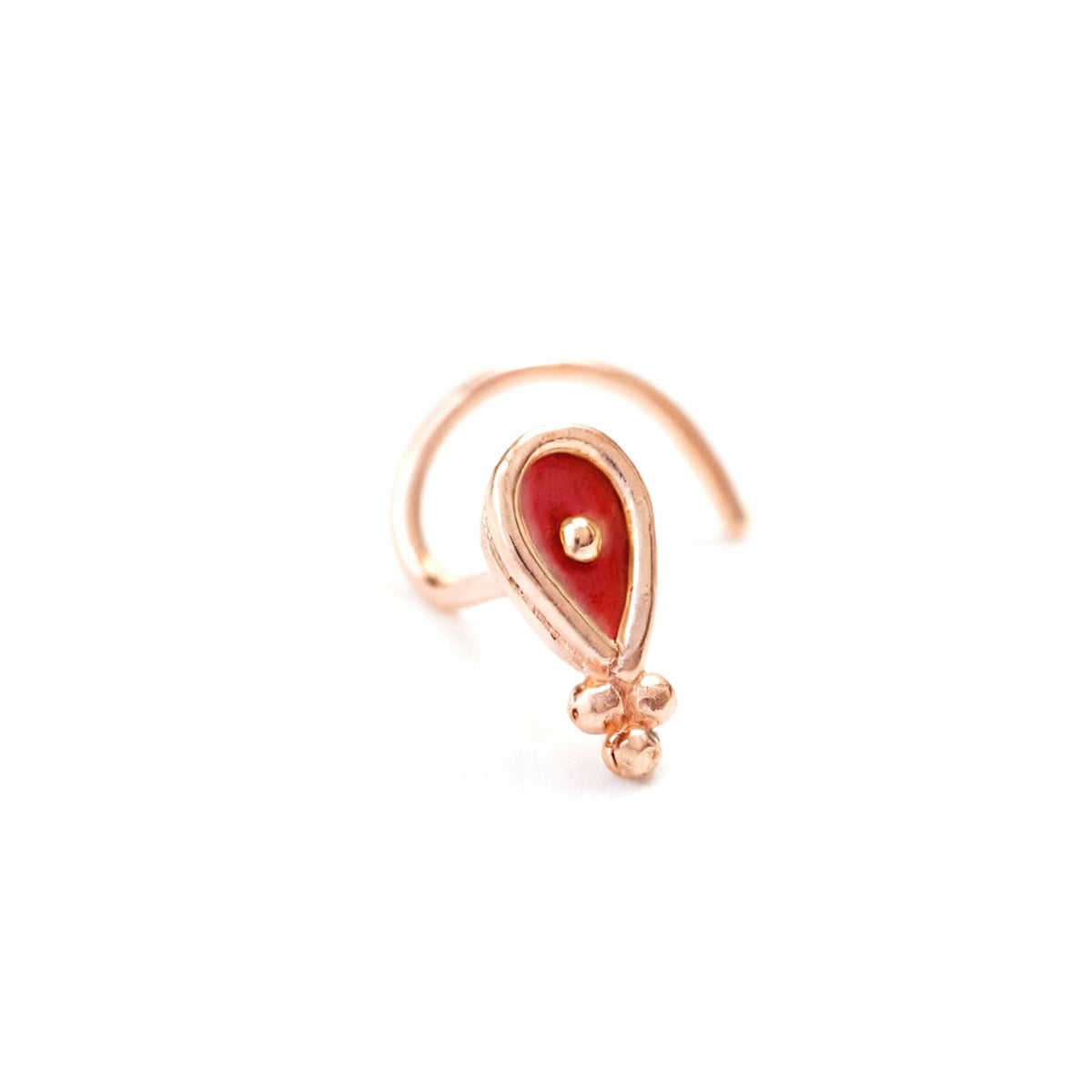 A single, ornate nose ring with a red center and a small, round gemstone.