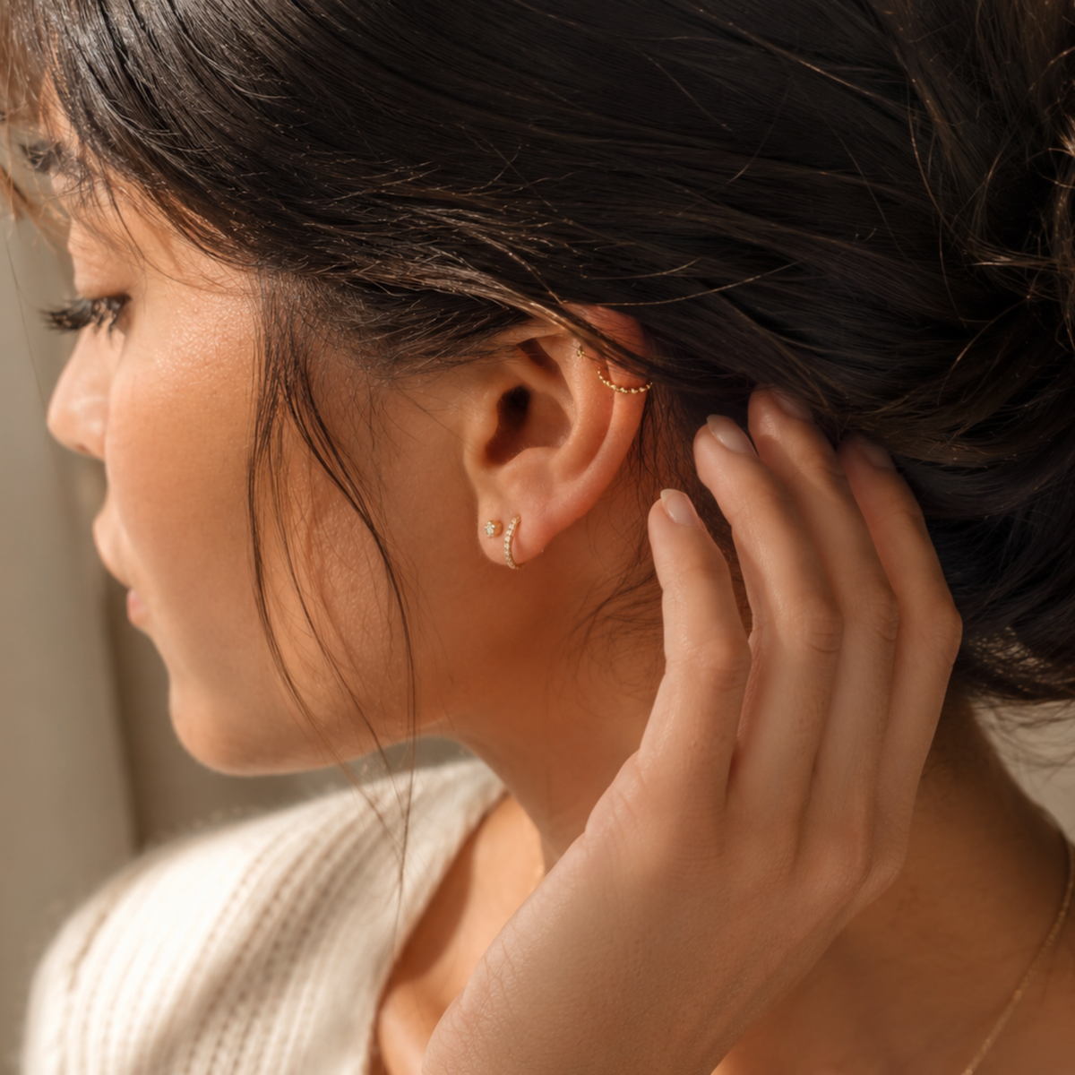 A close-up of a woman's face, focusing on her earrings and hair.