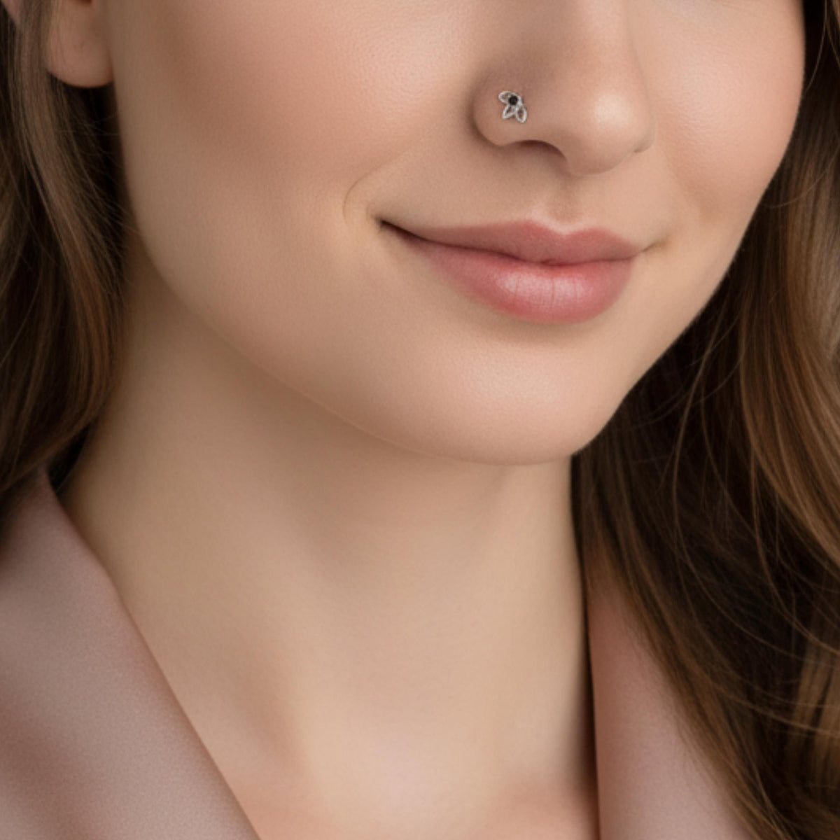 A close-up of a woman's face, focusing on her nose and lips. She is wearing a pink jacket and has a small nose stud.