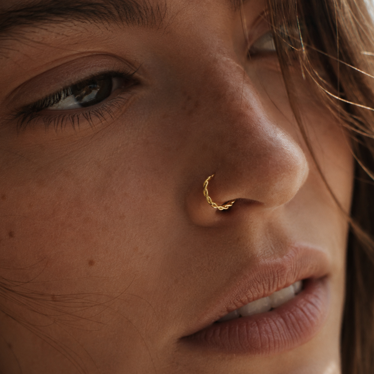 A close-up of a woman's face, focusing on her nose and eye.