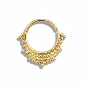 A gold-colored metal ring with a decorative design featuring small balls or beads around the edges.