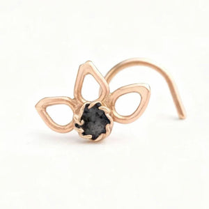 A gold-colored nose ring with a small black gemstone in the center.