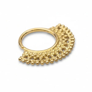 A gold-colored metal nose ring with a decorative, textured design.