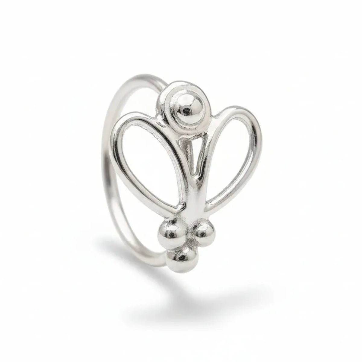 A silver ring with a unique, intricate design sits on a black surface.