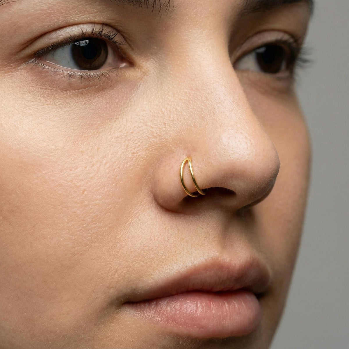 Double Gold Nose Hoop: A close-up of a person's face, focusing on their nose and lips.