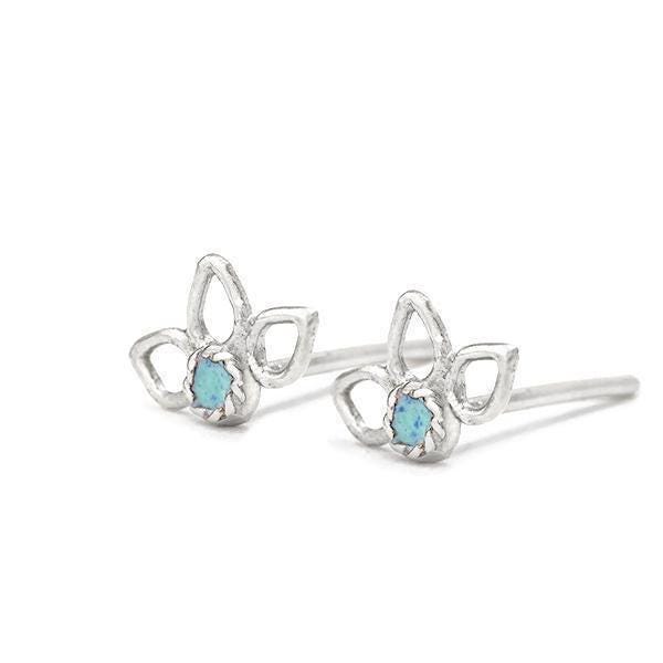 A pair of silver earrings with blue gemstones resting on a white background.