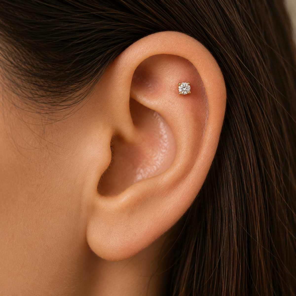 A close-up of a person's ear with a small diamond earring in the earlobe.