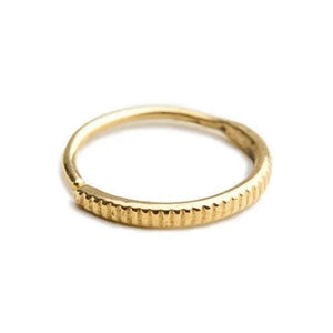 A gold-colored ring with a textured band.