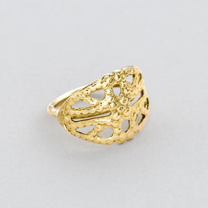 A gold ring with an intricate, leaf-like design.