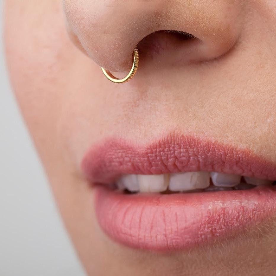 Solid Gold Nose Hoop: A close-up of a person's face, focusing on their lips and nose.