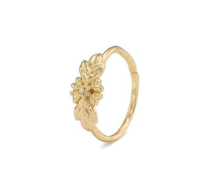 A gold-colored ring with a leaf-shaped design on the top.