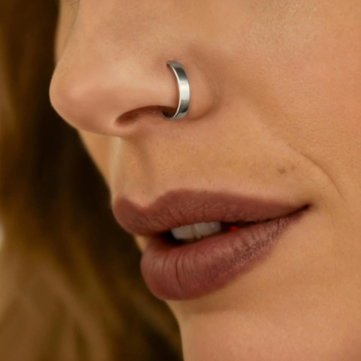Nose Ring Hoop: A close-up of a person's face, focusing on their nose and lips.