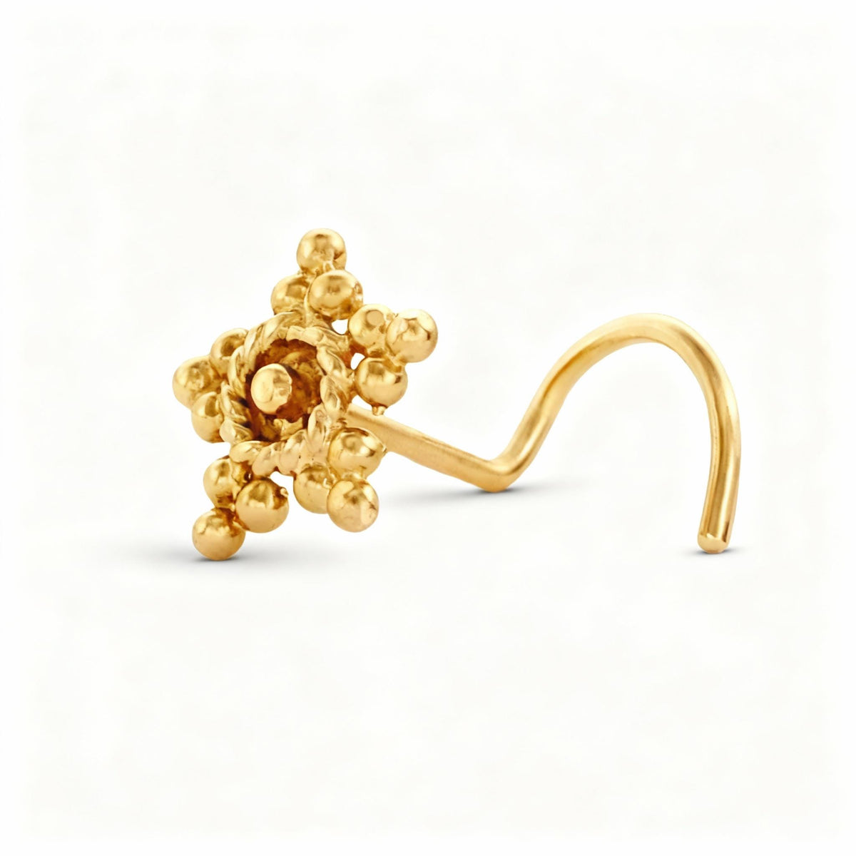 A gold-colored nose stud with a star-shaped design and small balls or stones.