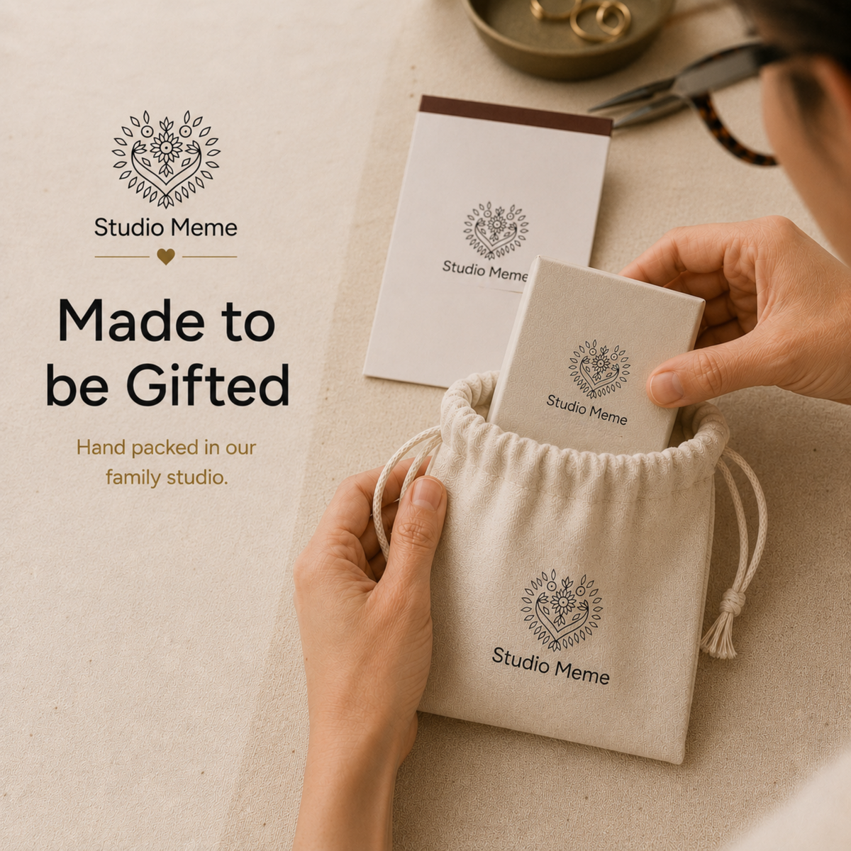 a set of jewelry items, including a white paper bag, a small white box, and a white paper bag, all with the logo of Studio Meme prominently displayed.