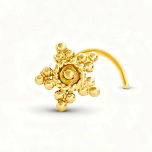 A gold-colored nose ring with a star-shaped design and small round balls.