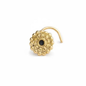 A gold-colored nose ring with a black gemstone in the center.