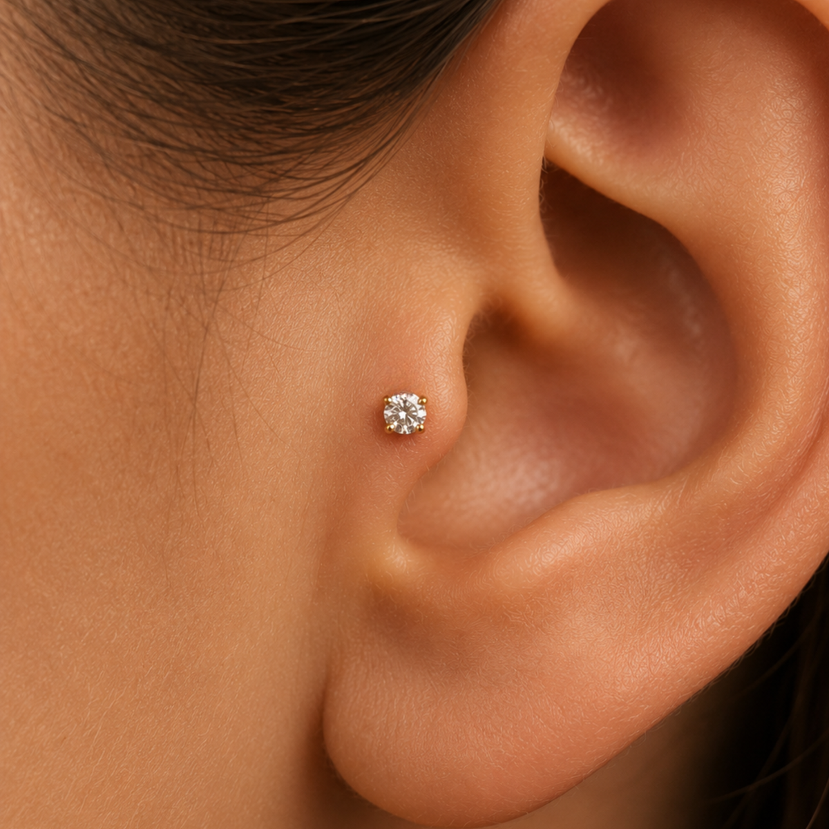 A close-up of a person's ear with a small diamond earring inserted in the earlobe.