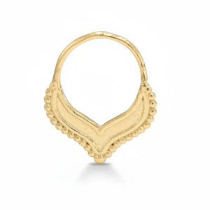 A gold-colored pendant with a decorative design, featuring a v-shaped motif with small round beads or stones around the edges.