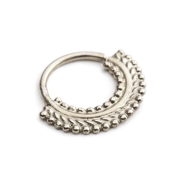 A silver-colored metal ring with a decorative design on the surface.