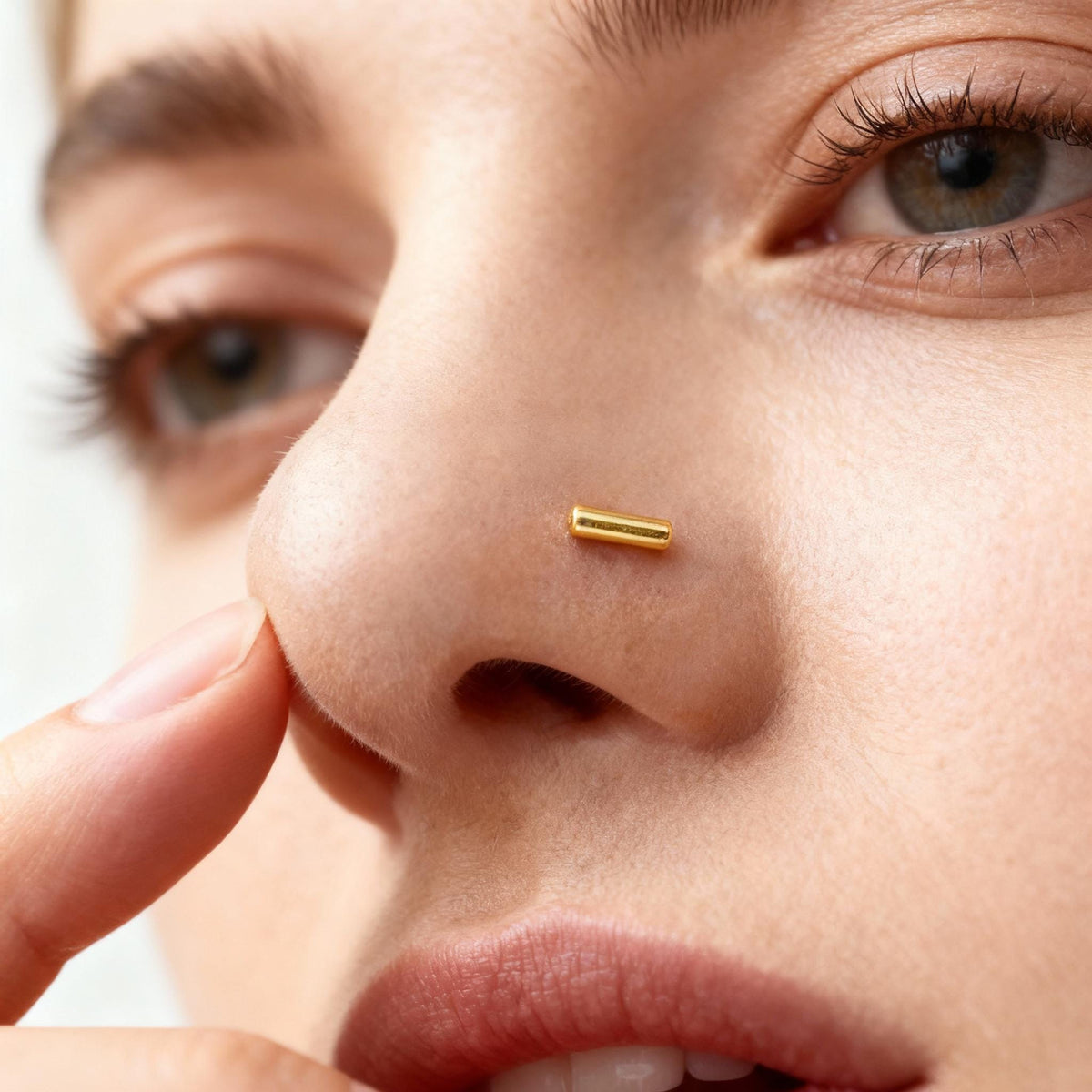 A close-up of a person's face, focusing on their nose and fingers.