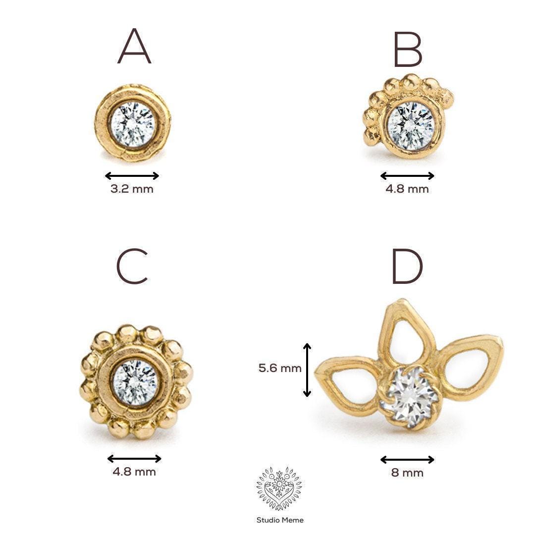 Four different gold-colored earrings with a central diamond, each with a unique size indicated by the corresponding measurement marks.