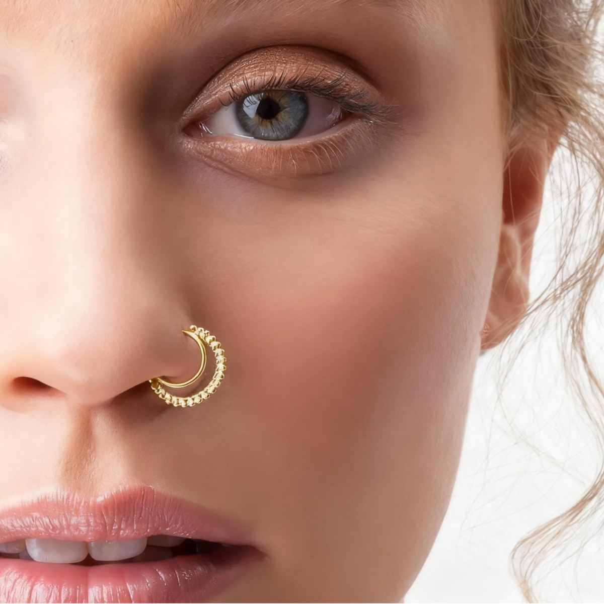 A close-up of a woman's face, focusing on her nose and eye.