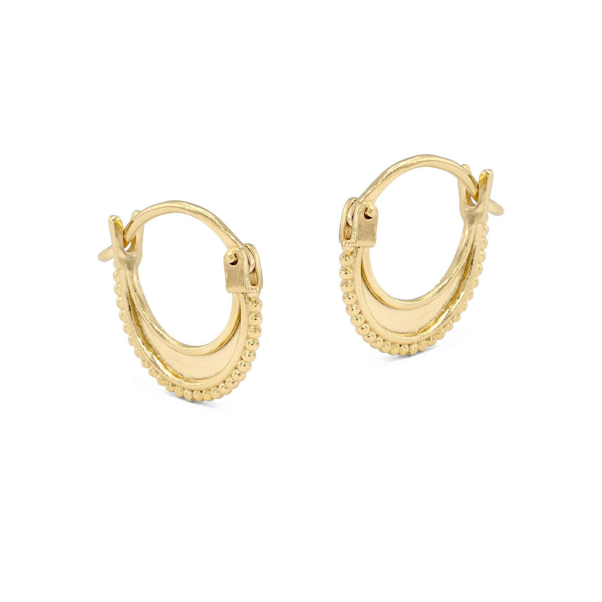A pair of gold earrings with a curved design and small beads around the edges.